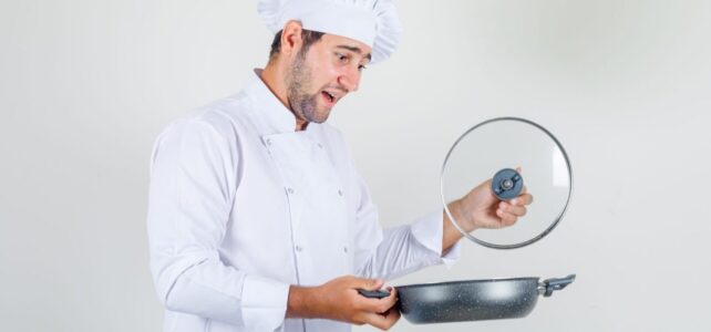 Composer sa batterie : quelle poêle choisir selon chaque cuisson ? Cuisinier comparant plusieurs poêles sur un plan de travail en cuisine.
